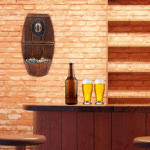 Décapsuleur mural fixé sur un mur en briques au-dessus d’un bar avec bouteilles et verres