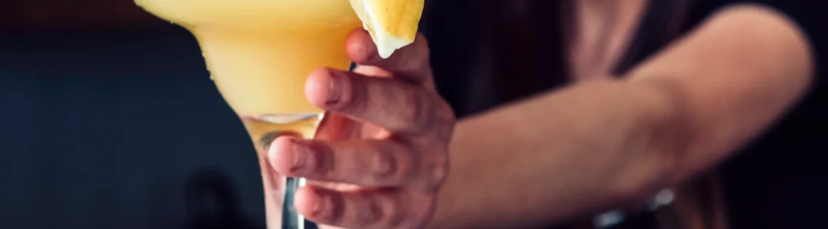 smiling female bartender serving drink with lemon 11zon